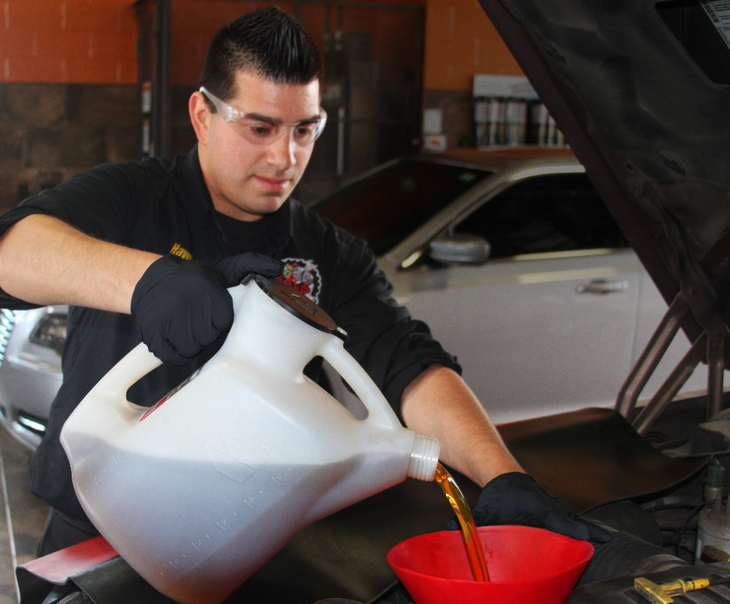 Havoline pro pouring oil into vehicle Havoline pro pouring oil into vehicle