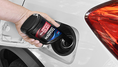 Techron Complete Fuel System Cleaner Being Poured Into Gas Tank Fuel additive